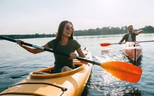 Happy Young Couple Smiling While Kayaking - Tamatha L Johnson Brentwood Dental Designs New Hampshire