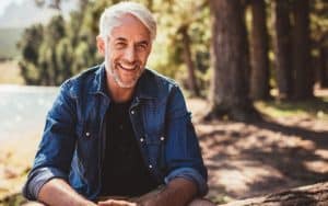 Older Man Smiling Near Lake With Dental Implants - Tamatha L Johnson Brentwood Dental Designs New Hampshire